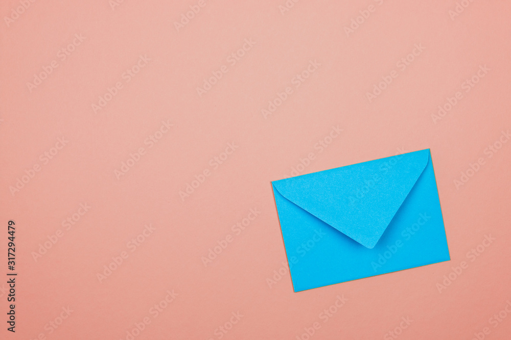 blue closed envelope in corner of a pink background blue closed envelope in corner of a pink background
