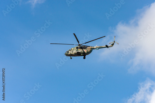 The military helicopter against the blue sky.
