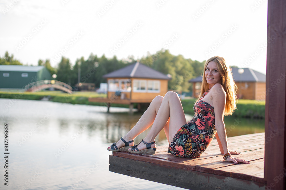 young woman sitting on a bench river lake
