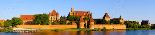 Panoramic view of the defense walls and towers of the Medieval Teutonic Order Castle in Malbork, Poland from across the Nogat river photo