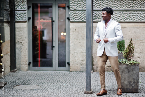 Thoughtful young handsome african american gentleman in formalwear. Black stylish model man in white jacket.