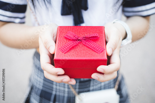 A woman with a red gift box. © Jakkit