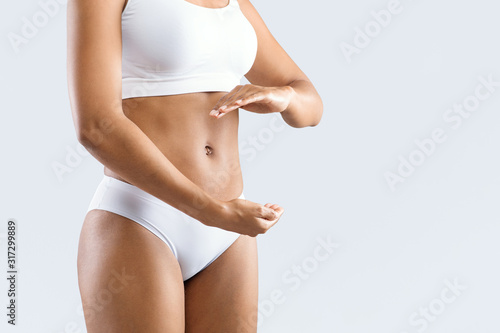 Pregnant black woman holding her hands next to belly