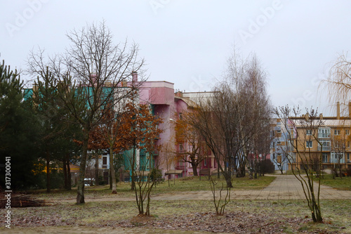 Spring trees and bright low houses. Small park in the courtyard of houses