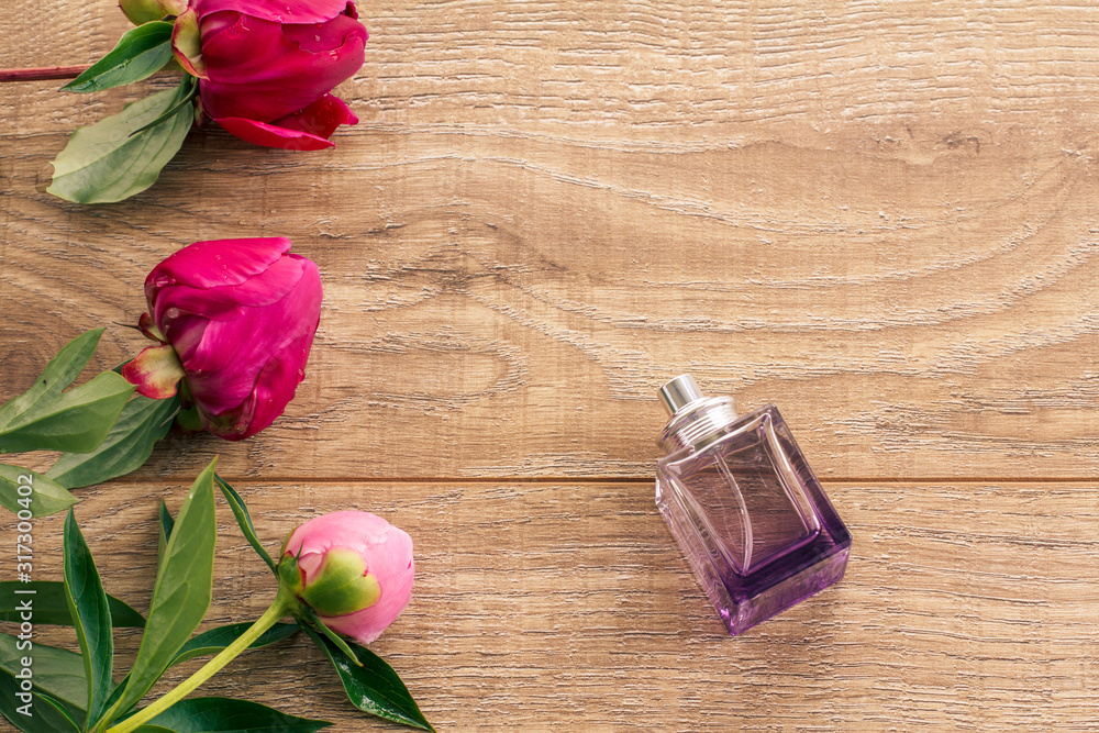 Bottle of perfume on wooden boards with peony flowers. Bottle of perfume on wooden boards with peony flowers.