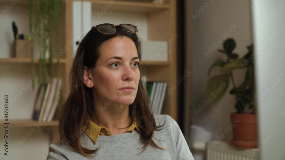 Attractive businesswoman sitting at the desk indoors in office. Attractive businesswoman sitting at the desk indoors in office.