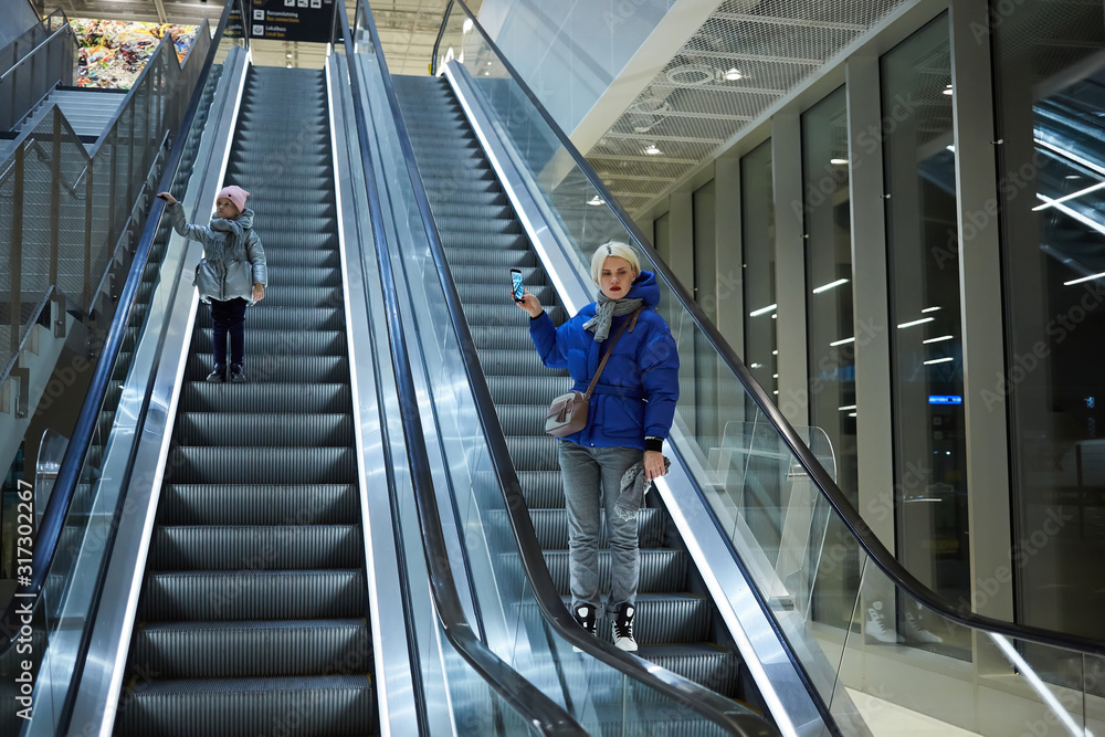 Obraz premium Mother and child together on escalator background. Terminal, airport travel, love care.