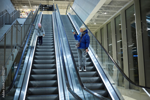 Mother and child together on escalator background. Terminal, airport travel, love care.