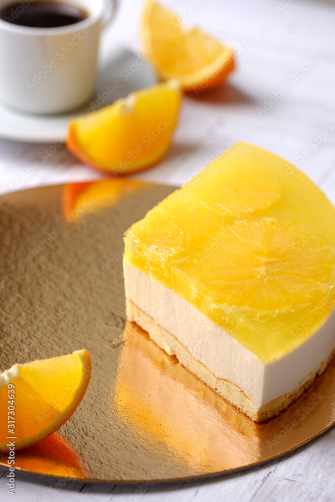 Tasty piece of fruit orange cake, mousse dessert on cup of coffee americano, white background. Homemade delicious sweet passion dessert sugarless. Healthy eating. Tasty piece of fruit orange cake, mousse dessert on cup of coffee americano, white background. Homemade delicious sweet passion dessert sugarless. Healthy eating.
