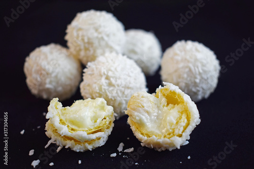 Coconut candy with nuts isolated on a black background.