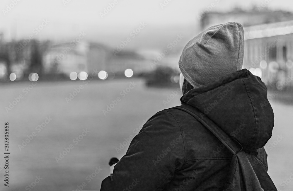 Portrait of a girl from the back looking at the river. Winter evening in the city. Portrait of a girl from the back looking at the river. Winter evening in the city.
