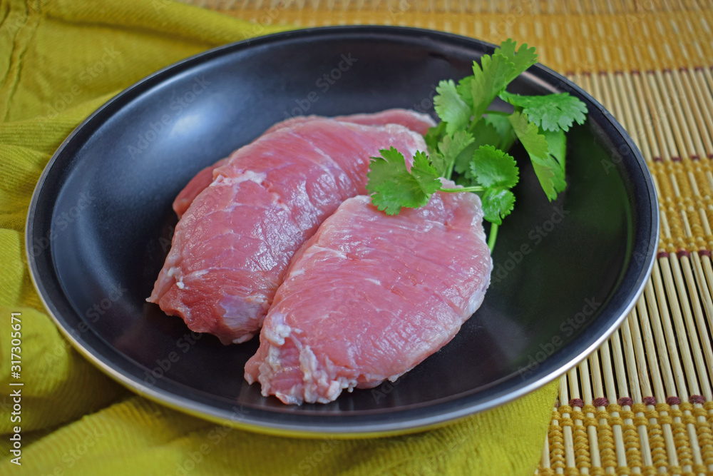 Raw meat in a pan with herbs.Steak.