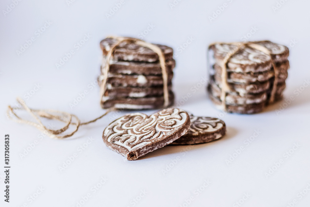 Naklejka premium On a blurred background, chocolate cookies with heart shaped icing. Handmade baking for Valentine's Day.Selective focus.