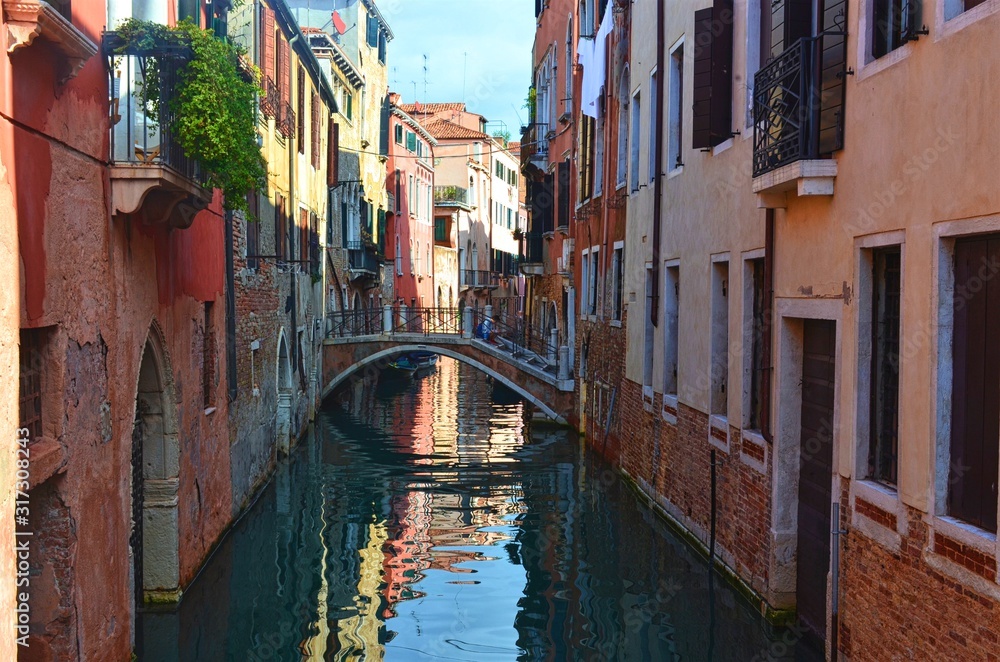 quiet small Venetian canal with a bridge between the houses