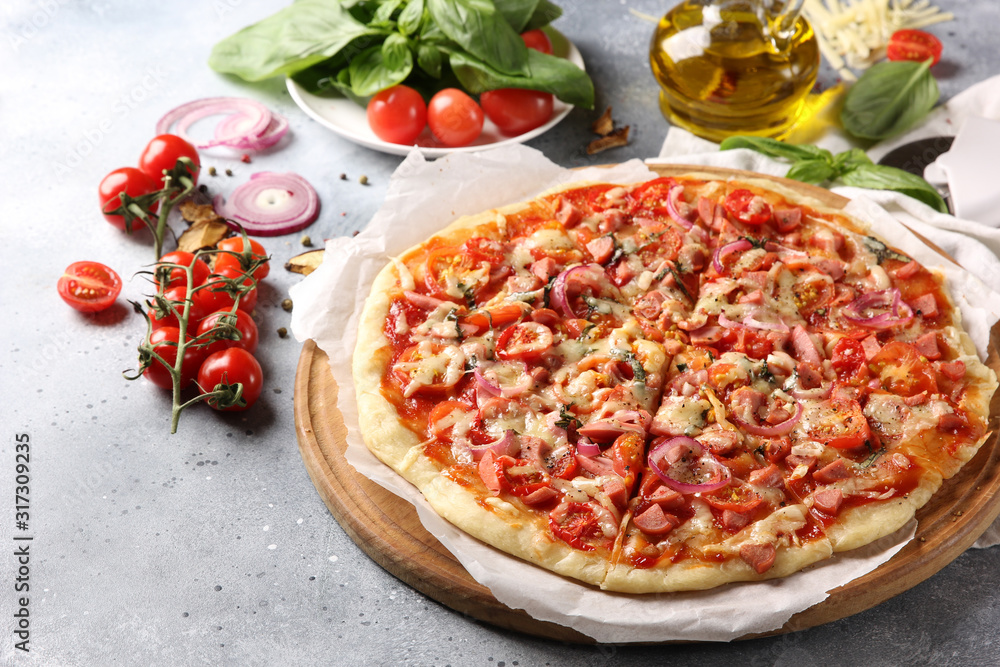 Italian cuisine. Pizza on a white and gray background. Cooking process. Fresh vegetables and basil. background image, copy space, pizza with hands.