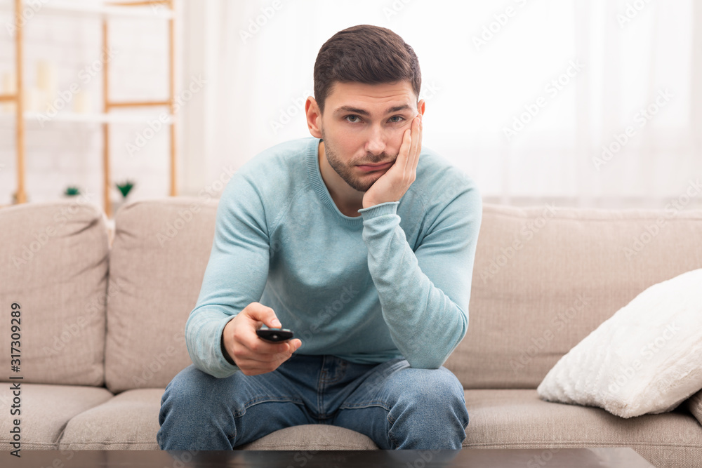 Bored Guy Switching Channels Watching TV Sitting On Couch Indoor Bored Guy Switching Channels Watching TV Sitting On Couch Indoor