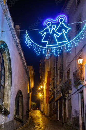 view on an ancient european illuminated street at christmas night