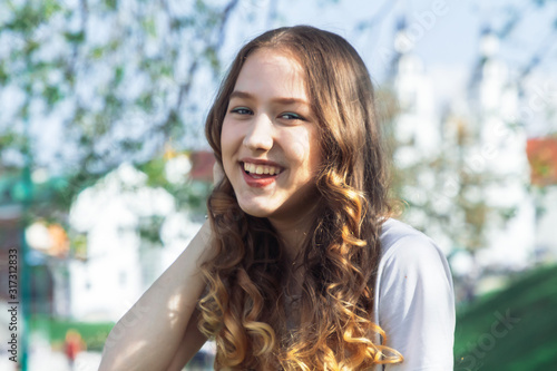 Happy beautiful young girl standing in a park