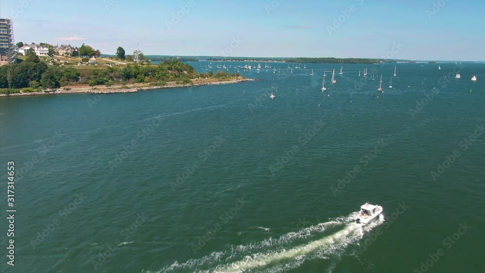 Aerial: Motor Boat in the harbor. In the background is Fort Allen Park. Portland, Maine, USA. Aerial: Motor Boat in the harbor. In the background is Fort Allen Park. Portland, Maine, USA.