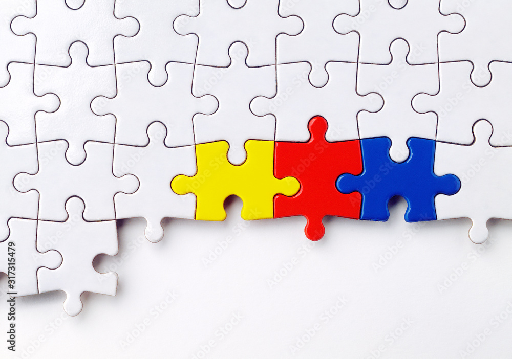 ein weißes Puzzle mit drei farbigen Puzzelteilen ein weißes Puzzle mit drei farbigen Puzzelteilen