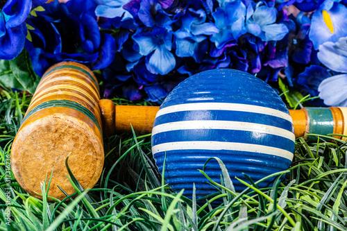 blue croquet ball and wooden mallet with blue flowers photo