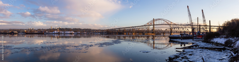 Beautiful Panoramic View of Fraser River and Pattullo Bridge in the City during a cold and icy winter sunset. Taken in New Westminster, Vancouver, British Columbia, Canada.