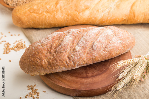 Different kinds of fresh baked bread on a white wooden background. side view, selective focus.