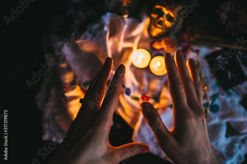 Witchcraft composition with burning candles, jewelry and skull . Halloween and occult concept, black magic ritual.