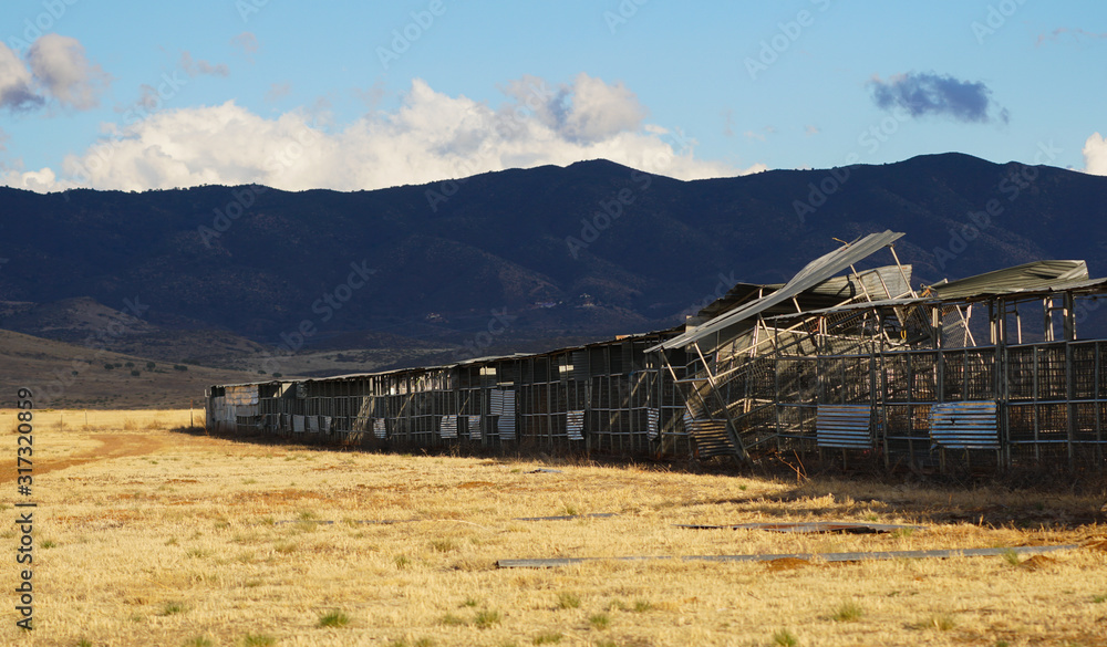 Old and abandoned livestock pens once used for fairs and rodeos sit in a rural field in the southwest.