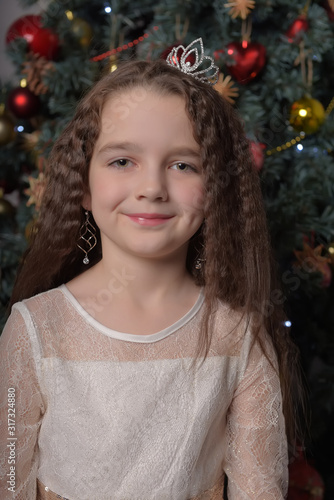 girl in ivory festive dress in christmas with a crown