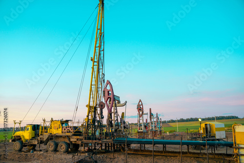 Workover rig working on a previously drilled well trying to restore production through repair. Service of oil-extracting installation.