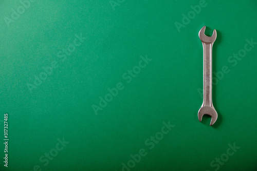Chrome wrench on a green background, top view, place for an inscription © grek881