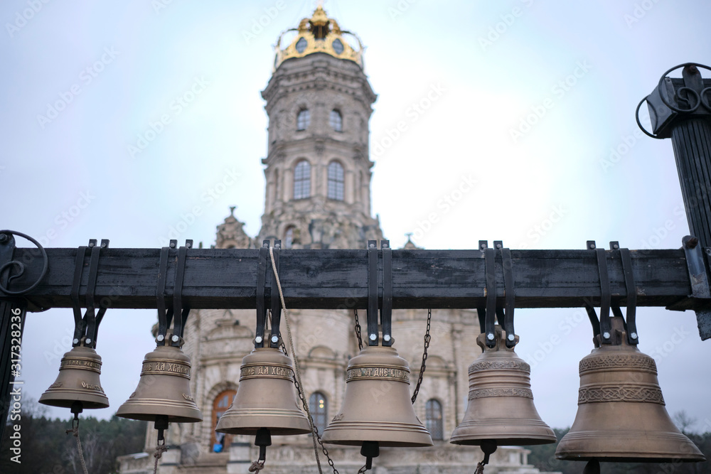 Bronze bells against the background of the church tower.