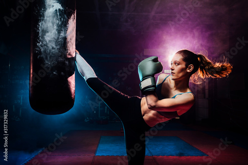 young woman training self defense giving a high kick to the punc
