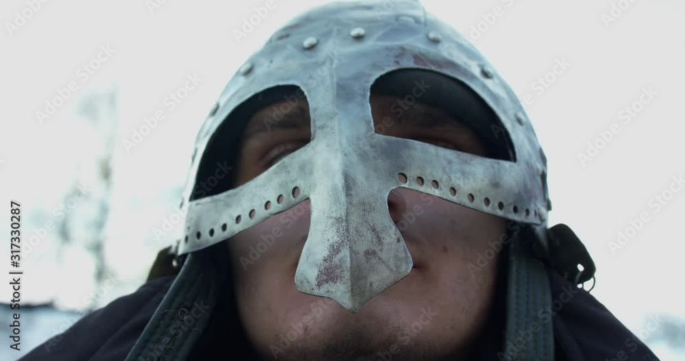 Close portrait of armed soldier in steel helmet looks at camera Close portrait of armed soldier in steel helmet looks at camera
