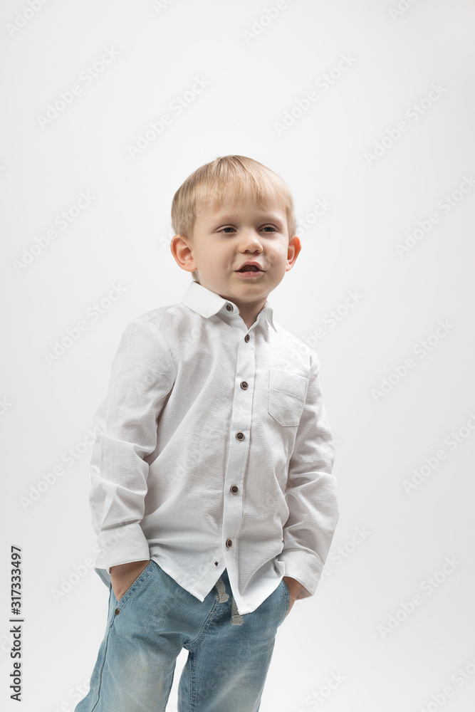 Portrait of a stylish and fashionable charismatic boy in a white shirt on a light background tells something. Portrait of a stylish and fashionable charismatic boy in a white shirt on a light background tells something.