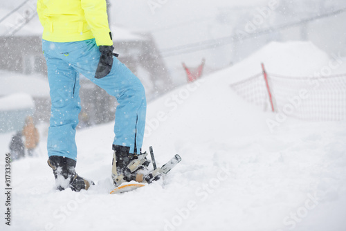 Girl a snowboarder is standing with snowboard in the snow blizzard.