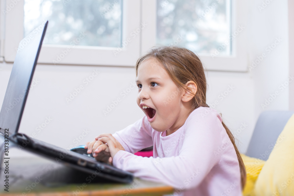 young girl enjoying using computer at home young girl enjoying using computer at home