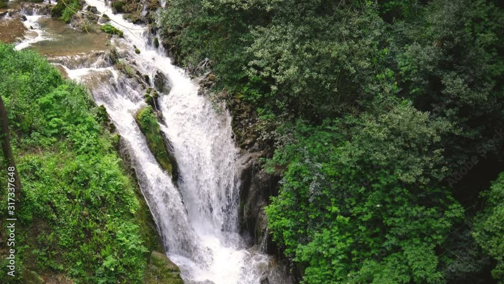 eden garden waterfall flowing cascade creek with lush vegetation - vertical panning eden garden waterfall flowing cascade creek with lush vegetation - vertical panning