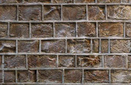 Old stone wall with uneven decorative joints. Unusual brick wall background.