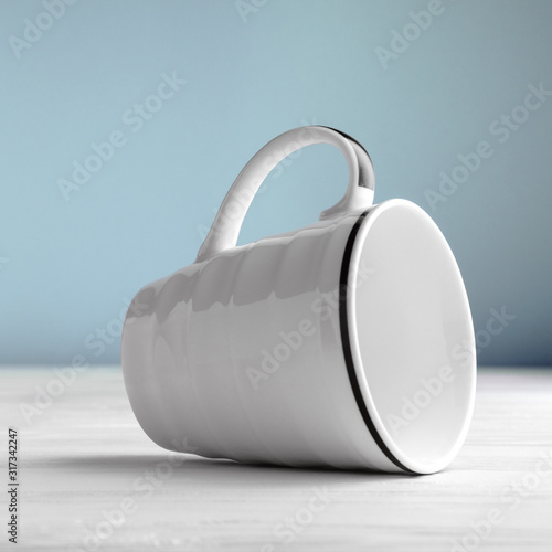 Wallpaper Mural White blank mug lying on side on white wooden table and blue background Torontodigital.ca