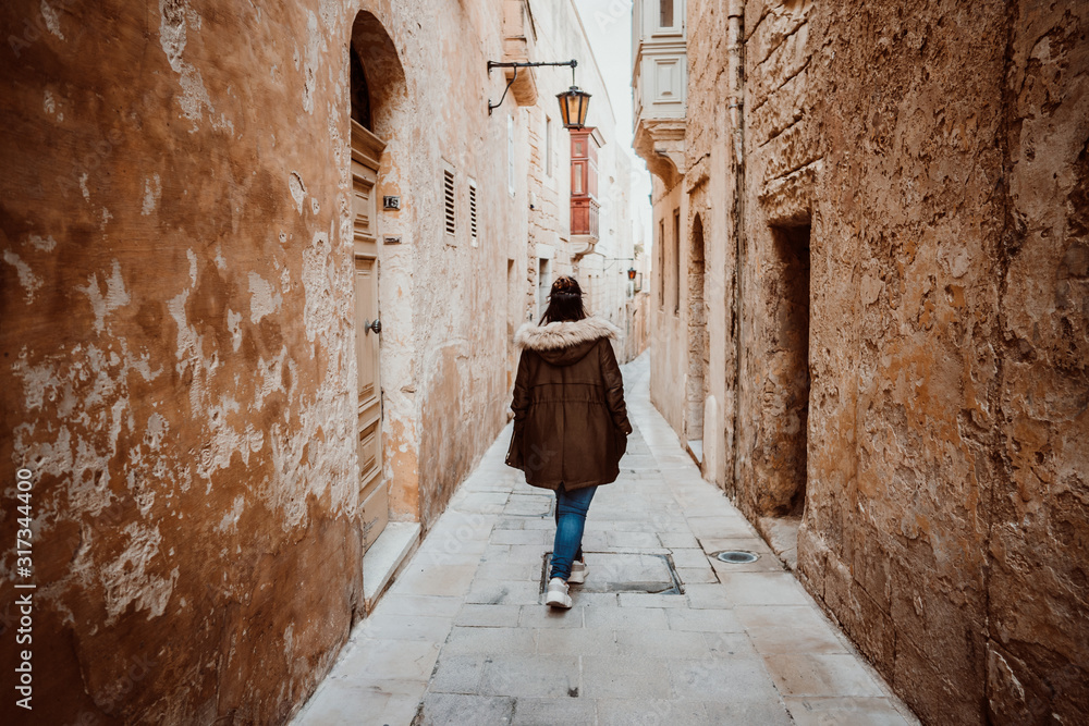 .Pretty young girl traveling around the island of Malta. Knowing its culture and visiting the old capital, Mdina, known as the Silent City. Relaxed and carefree. Travel photography. Lifestyle..