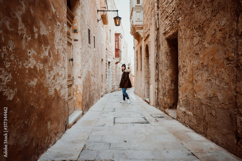 .Pretty young girl traveling around the island of Malta. Knowing its culture and visiting the old capital, Mdina, known as the Silent City. Relaxed and carefree. Travel photography. Lifestyle.. © lubero