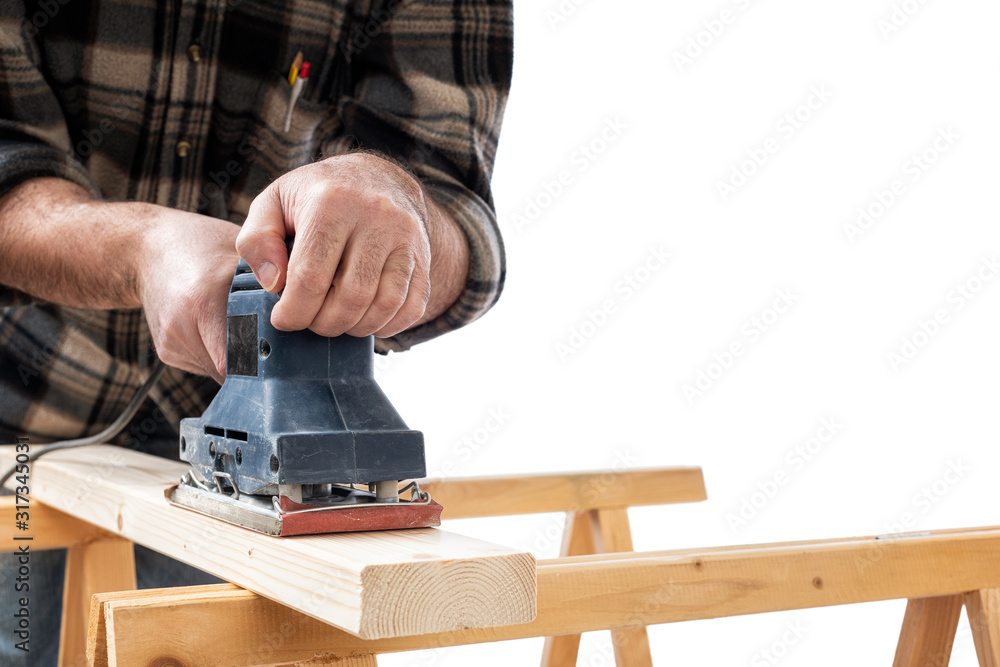 Close-up. Carpenter with the electric sander smoothes a wooden board. Construction industry. White background.