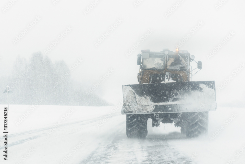 Naklejka premium Tractor is removing a snow from a road. Road service.