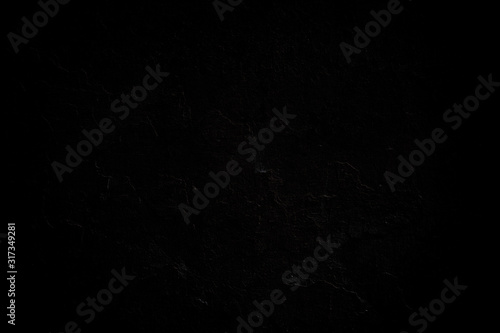 Close-up of a weathered and peeled off concrete wall. Dark, almost black, high resolution full frame textured background.