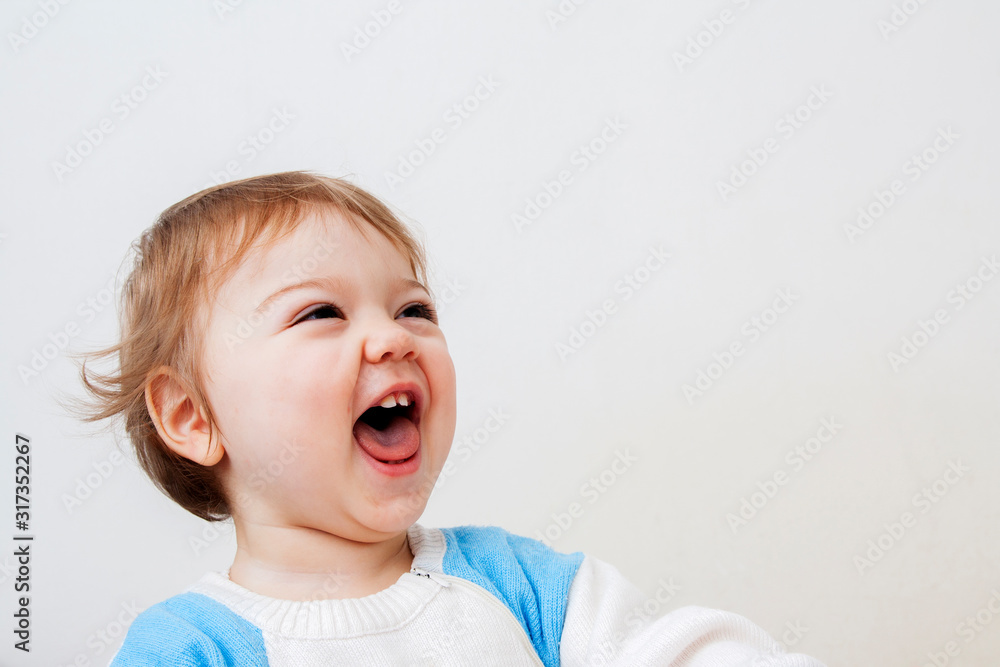 Cute little baby laughing a lot with open mouth on a white background. Happy baby with copy space for text Cute little baby laughing a lot with open mouth on a white background. Happy baby with copy space for text