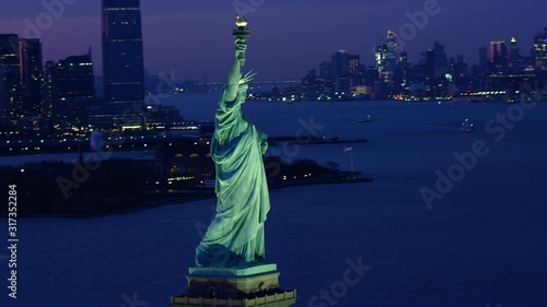 Aerial view of the Statue of Liberty at dusk. Manhattan and New Jersey skyline. New York City, United States. Shot from helicopter.