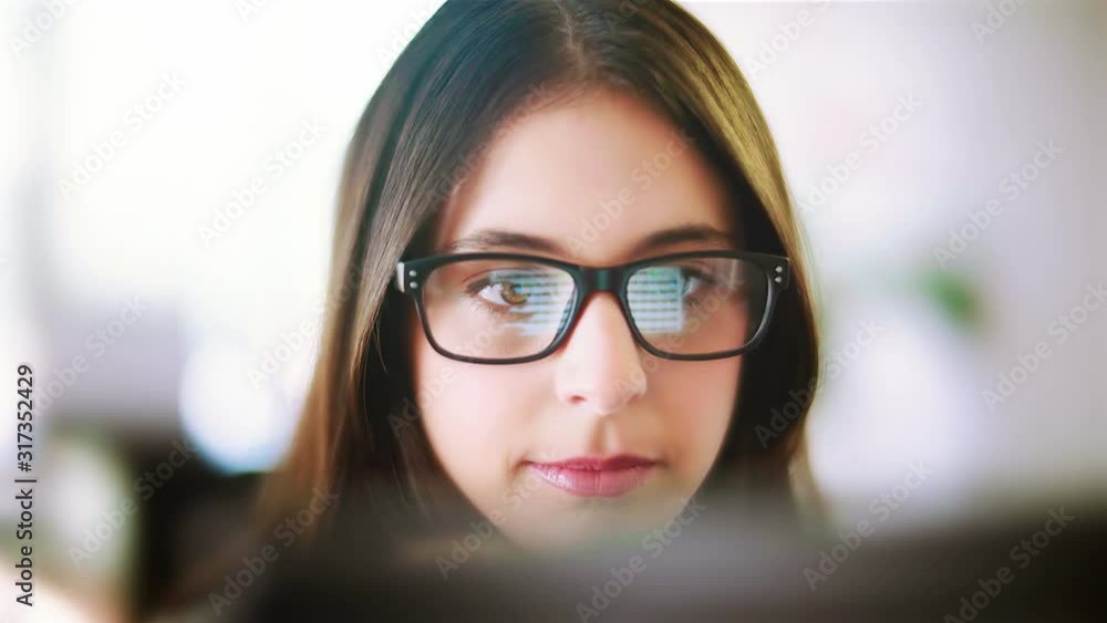 Attractive young woman working in a touchscreen computer or tablet. Businesswoman with glasses in an office space. Technology. Daylight. Dolly shot. Attractive young woman working in a touchscreen computer or tablet. Businesswoman with glasses in an office space. Technology. Daylight. Dolly shot.