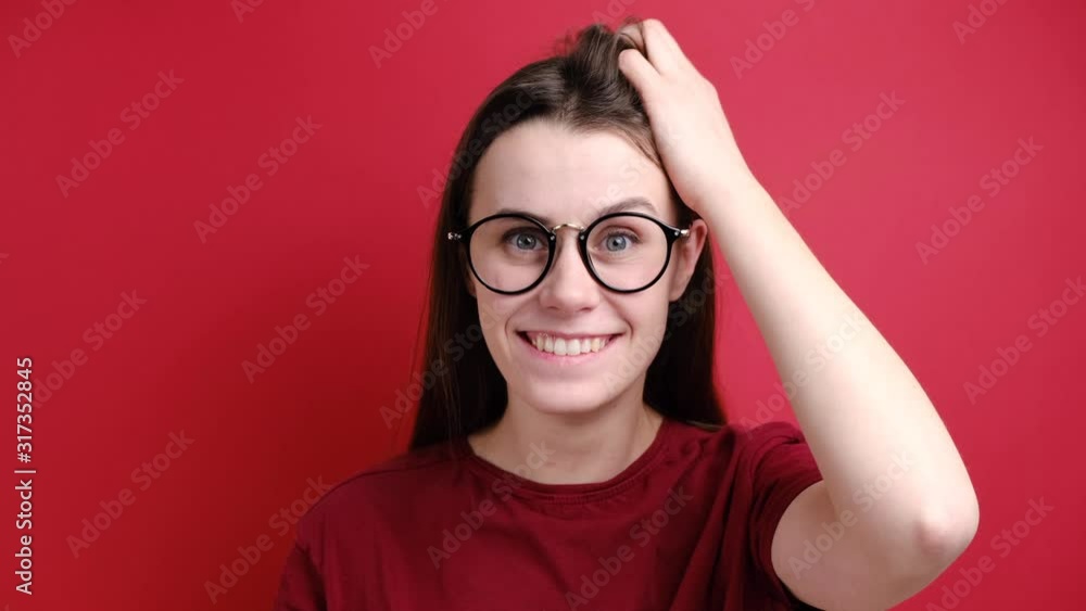 Stupefied shocked brunette woman in glasses keeps hand on head, has ...